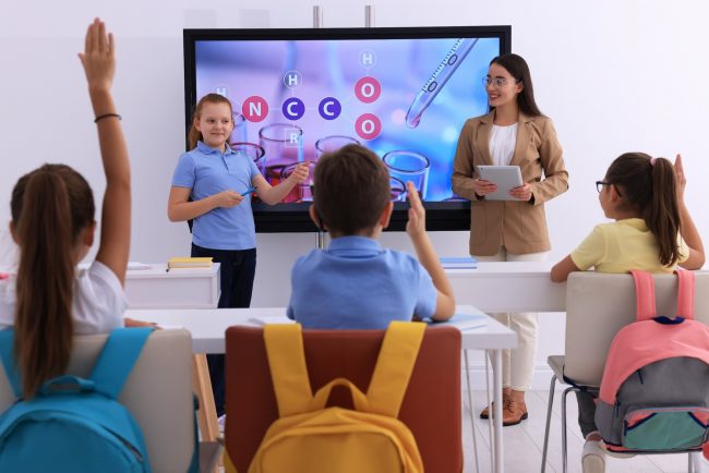 teacher using a smart board in class preparing teachers